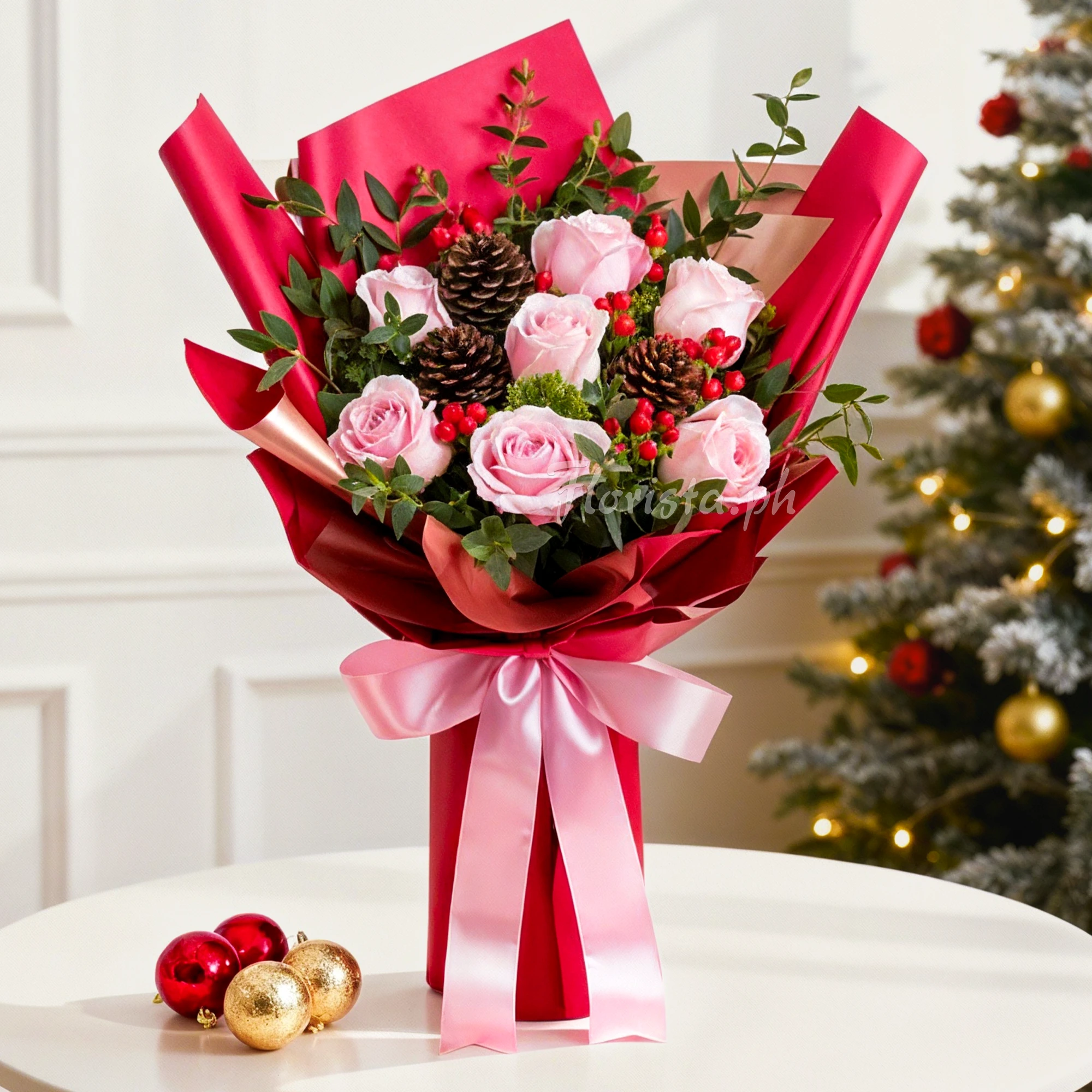 Bouquet of 7 pink roses with red berries and 3 pinecones with green fillers in a red wrapping paper tied with pink ribbons.